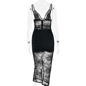 Detail view of the back of a black lace slip dress with mesh panels and sheer hem