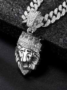 Close-up of silver lion head pendant with iced-out crown on a shiny Cuban link chain