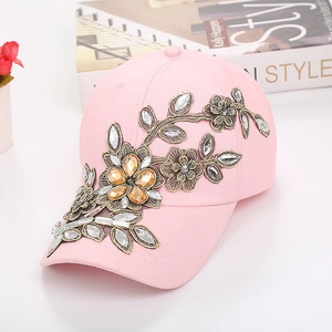 Détails de broderie de fleurs roses avec strass sur une casquette de baseball en jean