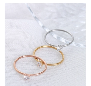 Three minimalist stackable rings in silver, gold, and rose gold with tiny zircon stones