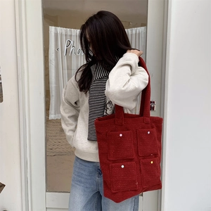 Detail of red plush tote bag with four square pockets and colorful dot accents