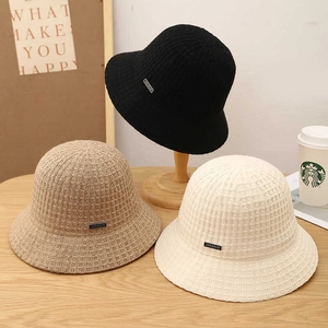 Three knitted bucket hats in black, khaki, and cream colors showing fine woven texture