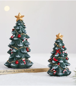 Miniature resin Christmas trees with snow effect and festive ornaments on fake snow
