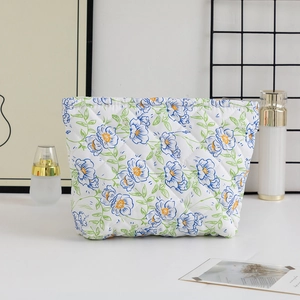 Detail of quilted floral makeup bag with blue flower pattern and large storage capacity