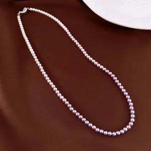 Elegant lavender pearl necklace with silver clasp on a dark silk background