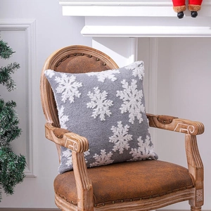Housse de coussin de Noël grise avec flocons blancs en tufté sur une chaise vintage