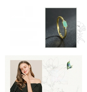 Dettaglio anello in oro con pietra Paraiba taglio smeraldo e diamanti laterali