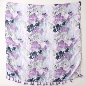 Detailed close-up of ink-wash floral print scarf with purple tassels on white background
