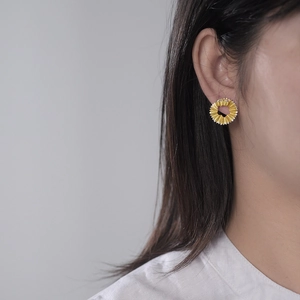 S925 sterling silver gold pleated disk earrings worn by model on grey background