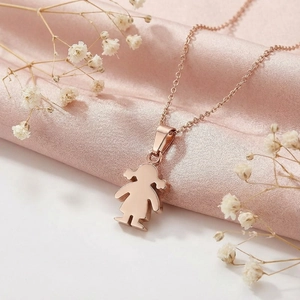 Macro detail of polished rose gold girl silhouette pendant and fine steel necklace chain
