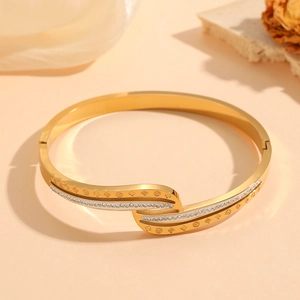Elegant 18K gold-plated twisted wave bangle with clover pattern and white rhinestones