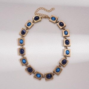 Makroaufnahme goldener geometrischer Glieder mit blauen Kristall- und Harzeinlagen