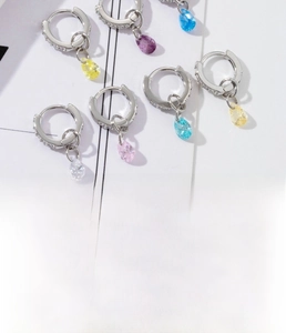 Macro view of colorful pear-cut zircon pendants on silver copper hoop earrings