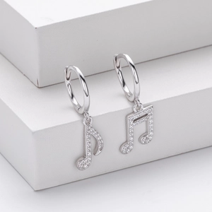 Close-up of S925 silver musical note earrings with sparkling pavé crystals