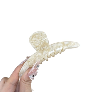 Elegant cream marble acetate hair claw clip with gold label for high ponytail styles