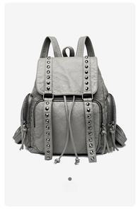 Detail view of grey vintage backpack with rivet decor and tassel zipper pockets