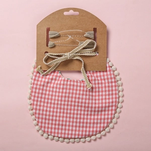 Détail du bavoir bébé vichy rouge avec bordure à pompons et bandeaux assortis