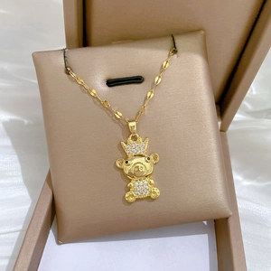 Detail of gold crown bear pendant necklace with white zirconia pave setting on display