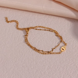 Double-layered golden Hamsa Hand bracelet on silk fabric with adjustable chain link