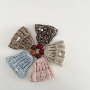 Detaillierte Draufsicht auf sechs bunte Rippstrickmützen mit dekorativen Pompons