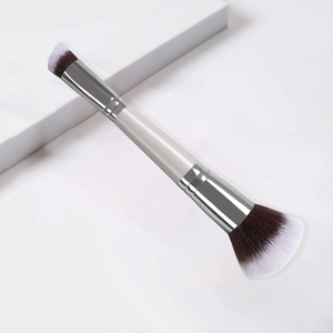 Detail showing dual-ended makeup brush with angled and fan bristles on silver metal handle