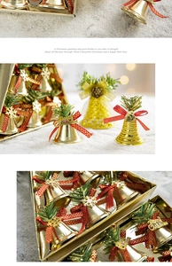 Close-up of golden Christmas bells with red bows and pine needles in a gift box