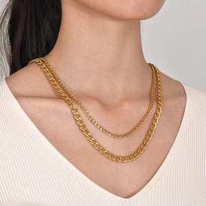 Dettaglio della collana a catena cubana dorata a strati con maglie lucide su un modello