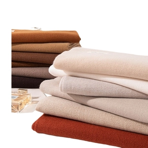 Stacked solid color cashmere-feel scarves in earthy tones for winter warmth and style