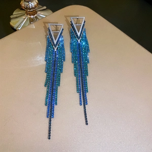Close-up of geometric tassel earrings with blue and green gradient rhinestones
