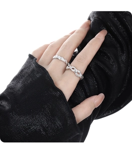 Close-up of silver woven knot rings with intricate braided texture on model hand