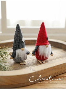 Detail of red and grey knitted Christmas gnomes with wooden skis in a cozy rustic setting