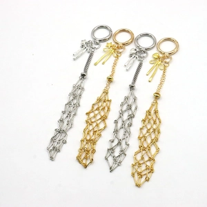 Détail de porte-clés à franges en maille métallique avec breloques étoile et nœud dorés