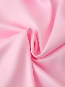 Macro shot of smooth pink satin fabric showing glossy texture and soft draping effect