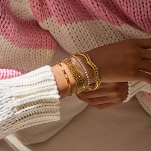 Gros plan de bracelets dentelle ajourée en or 18 carats avec bracelets chaîne et tennis