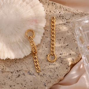 Vue détaillée des boucles d'oreilles dorées avec chaîne sur coquillage et pierre