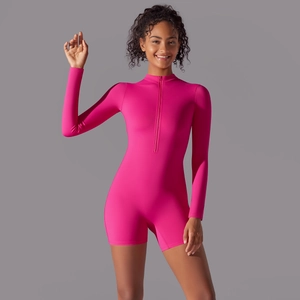 Detail of fuchsia long sleeve yoga romper featuring half-zip collar and stretchy fabric