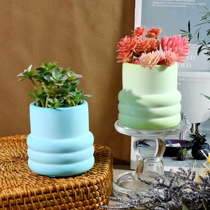 Dettaglio di vasi in ceramica opaca con trama a onde unica e sfumature di colore delicate