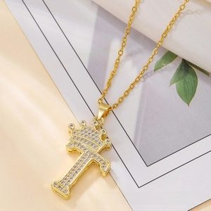 Macro detail of gold crown letter T pendant with pavé cubic zirconia on O-chain necklace