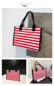 Detail of red and white striped canvas tote bag with black handles and magnetic snap closure