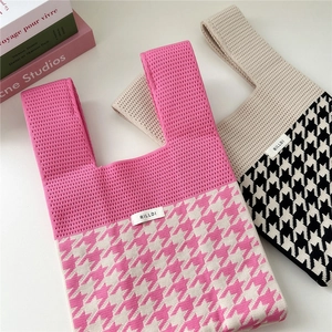 Houndstooth knit tote bag in pink and black patterns shown from a 45-degree angle
