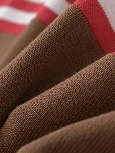 Close-up of soft brown knit fabric featuring red and white striped ribbed cuffs