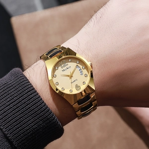 Close-up of gold tungsten watch dial with rhinestones and date display on wrist