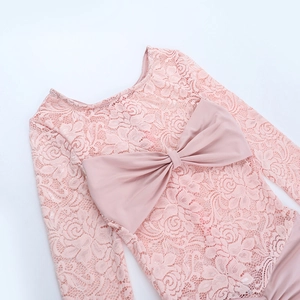 Close-up of pink lace jumpsuit detailing elegant satin bow and textured fabric