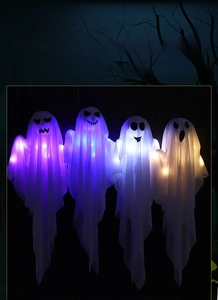 Close-up of four glowing Halloween ghost pendants with LED lights in multiple colors