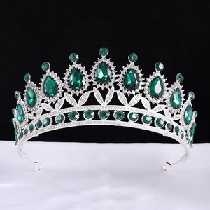 Detailed view of baroque silver crown with emerald teardrop gems and sparkling rhinestones