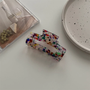 Detail einer großen rechteckigen Acetat-Haarklammer mit buntem Terrazzo-Muster im Ins-Stil