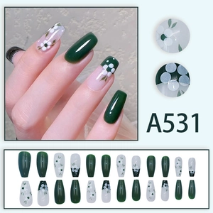 Summer green floral press-on nails with white dots in a long coffin shape set