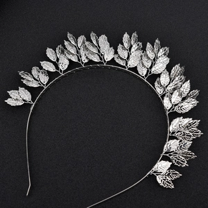 Detailed macro view of silver alloy leaf crown headband on a black textured backdrop