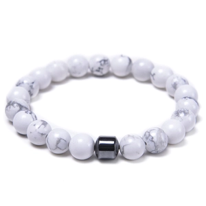 Macro detail of 8mm white turquoise beads with a black magnetic cylinder spacer bead