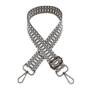 Detailed view of woven geometric wide bag strap with adjustable grey metal lobster clasps